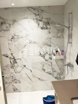 Modern bathroom with a walk-in shower lined with marble tiles. - image 7