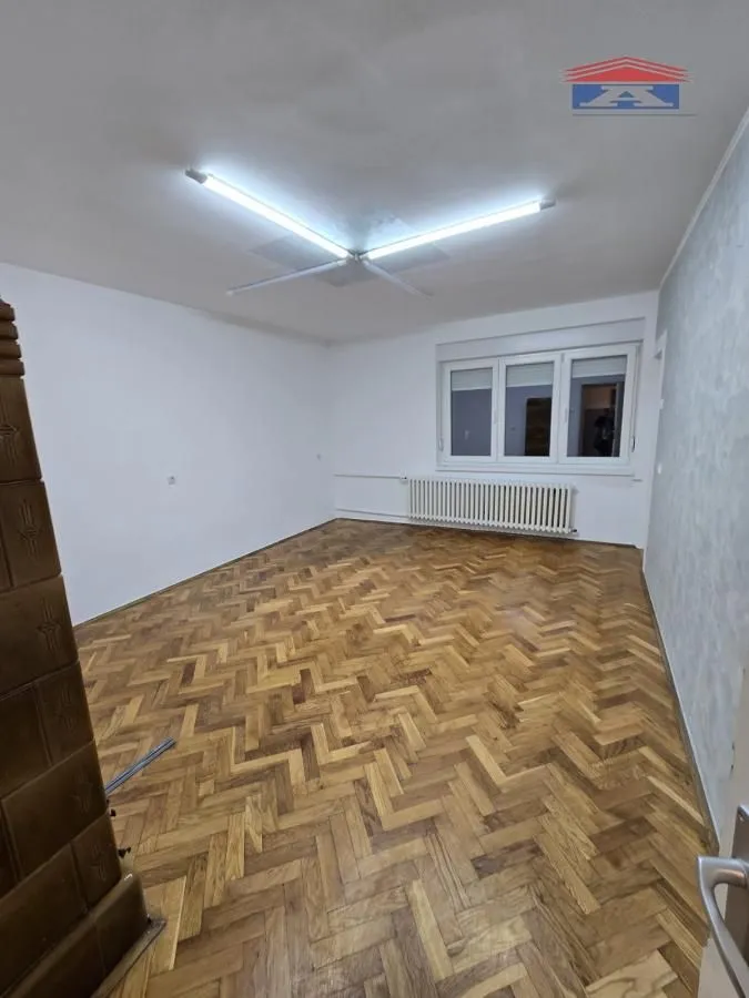 Empty room with parquet flooring and white walls.