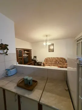 Pogled iz kuhinje prema dnevnoj sobi sa garniturom i vitrinom. - image 7
