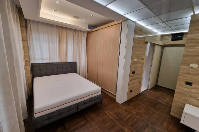 Bedroom with a double bed, large wardrobe, and parquet flooring.