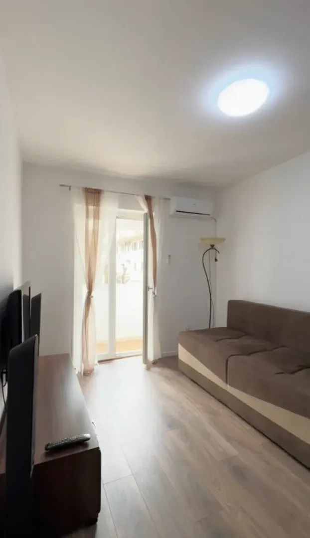 Living room with a sofa, television, and access to the terrace.