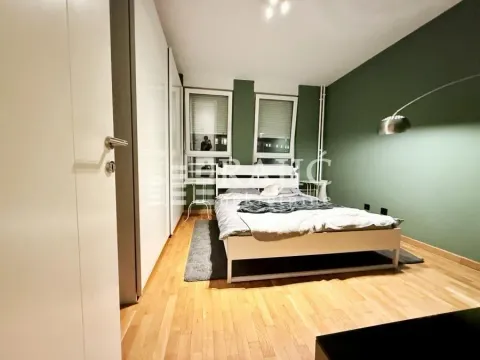 Modern bedroom with a double bed, white wardrobe, and green accent wall. - image 9
