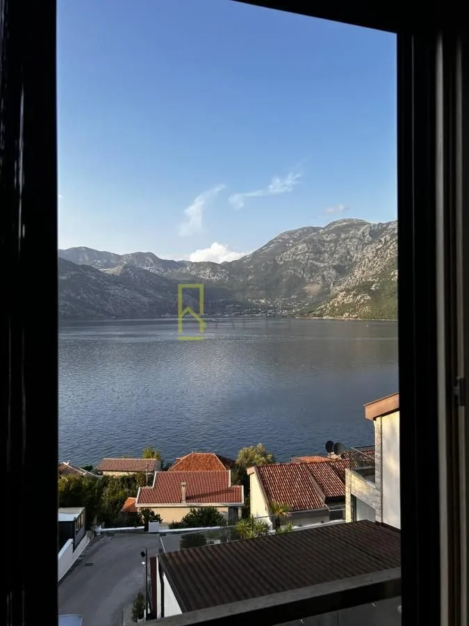 Pogled na zaliv i planine sa prozora nekretnine.
