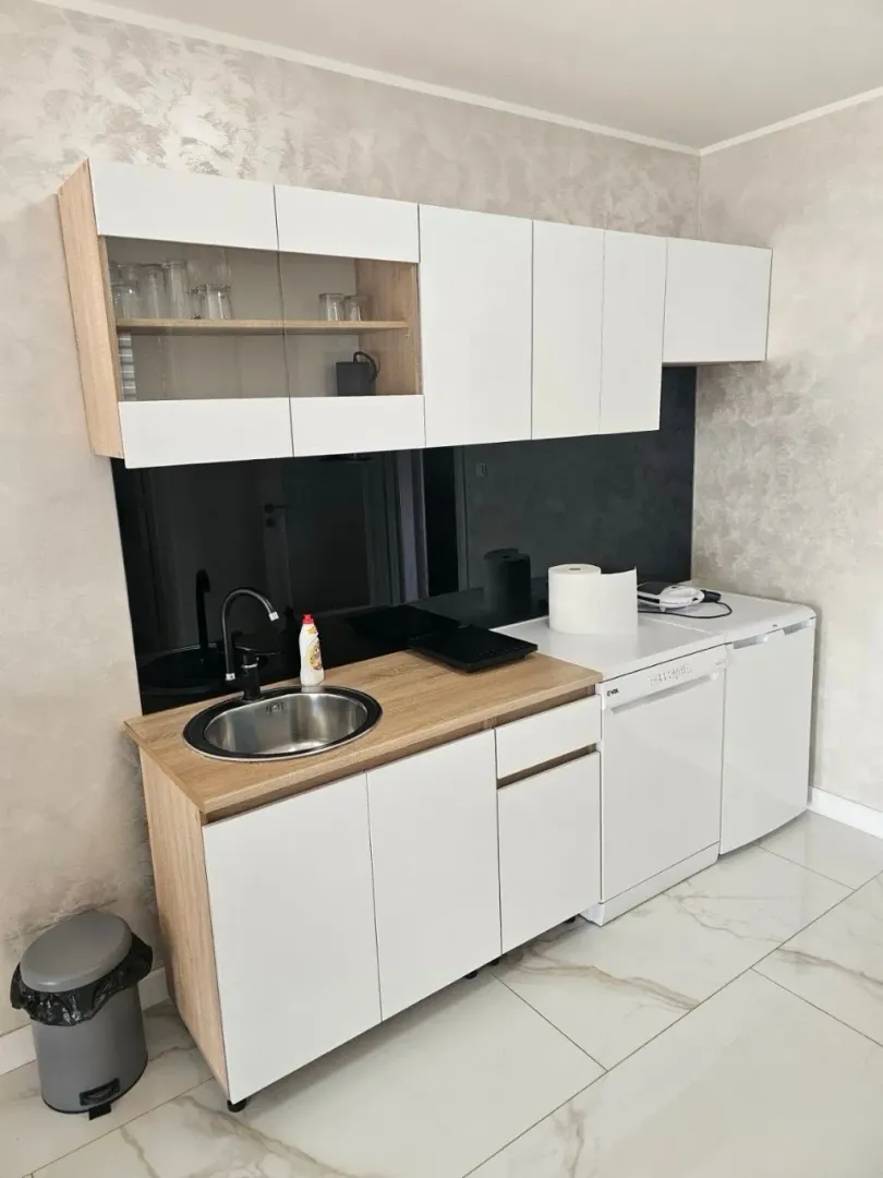 Smaller kitchen with white cabinetry, sink, and wood-patterned countertops.