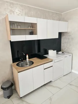 Smaller kitchen with white cabinetry, sink, and wood-patterned countertops. - image 3