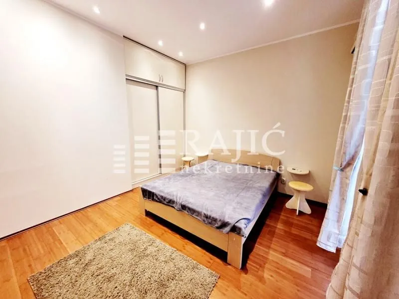 Furnished bedroom with a double bed, wardrobe, and wooden flooring.
