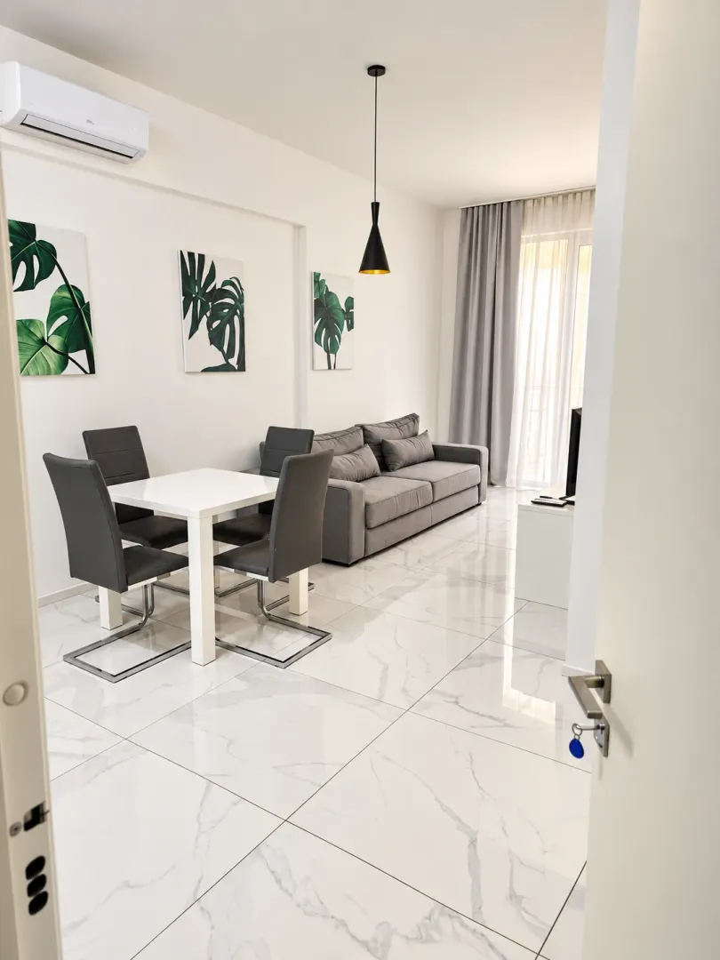 Bright living room with dining area, modern furniture, and ceramic tile flooring.