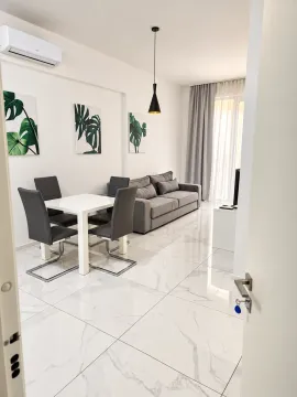 Bright living room with dining area, modern furniture, and ceramic tile flooring. - image 3