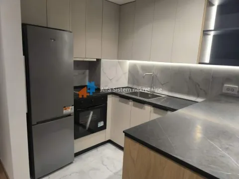 Modern kitchen with built-in appliances and a refrigerator. - image 10