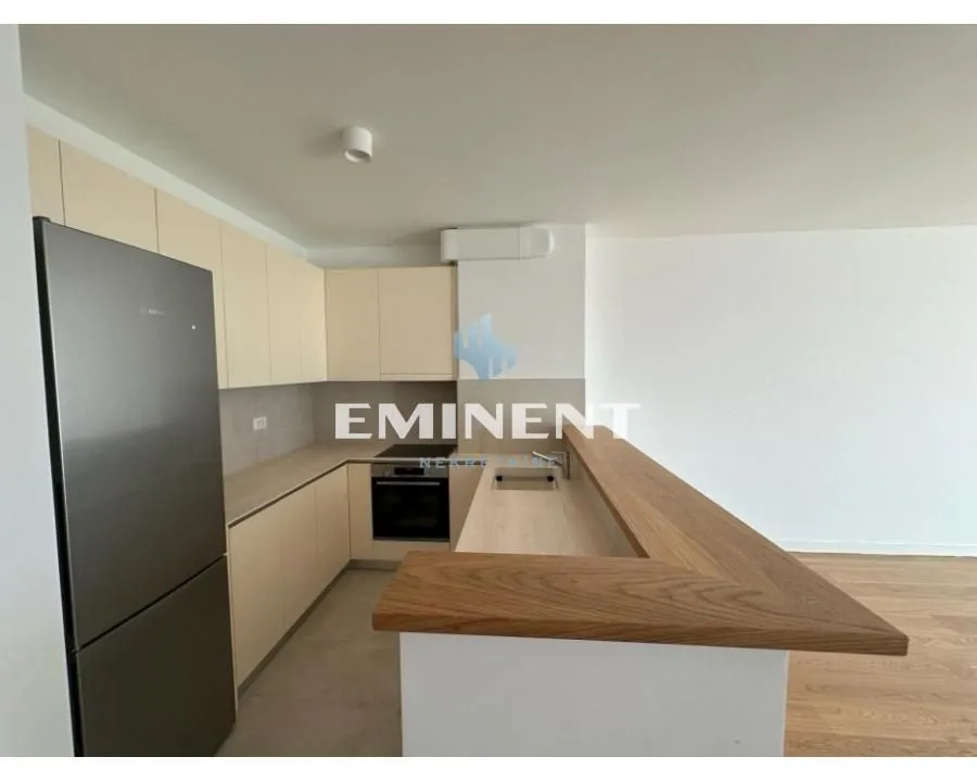Kitchen with light-colored cabinetry and a wooden breakfast bar.