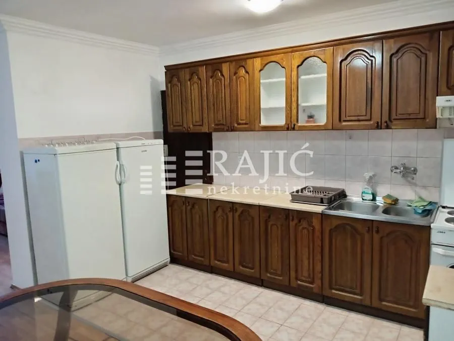 Kitchen with wooden cabinetry and two refrigerators.