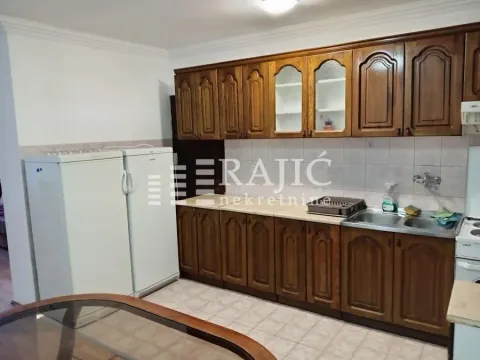 Kitchen with wooden cabinetry and two refrigerators. - image 6