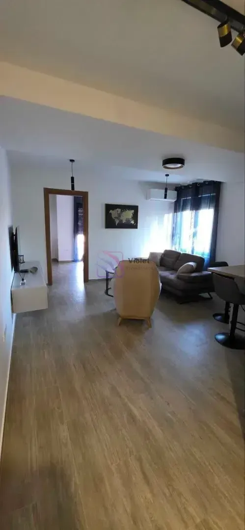 Dnevni boravak sa garniturom, foteljom i TV komodom.