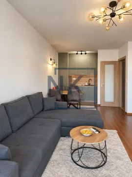 Living room with a sofa and coffee table, connected to the dining area and kitchen. - image 3