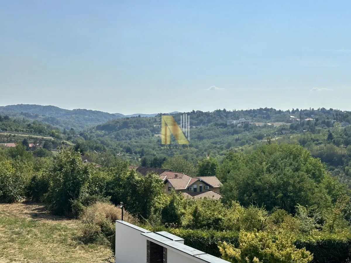 Pogled sa terase na zelene površine i okolna brda.