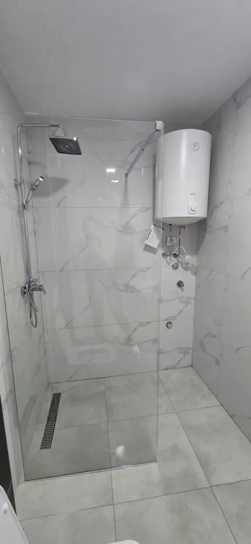 Moderne kupatilo sa tuš kabinom i bojlerom.