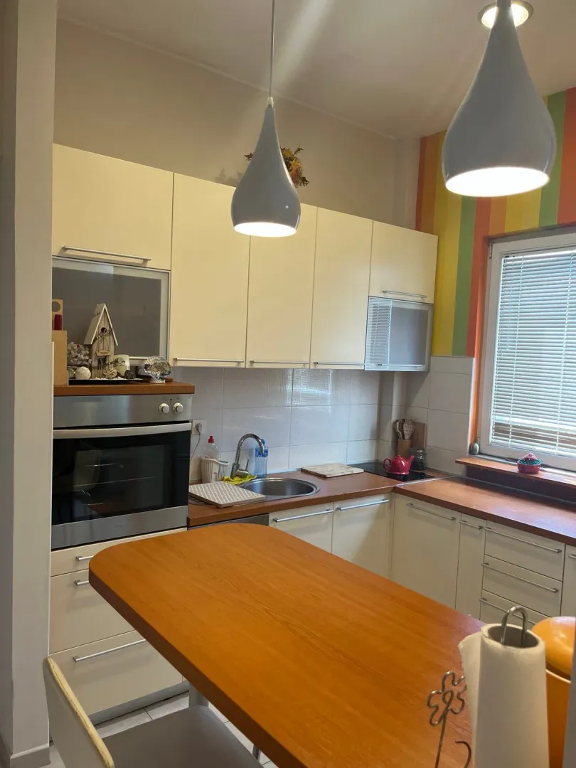 Kitchen equipped with wooden countertops, white cabinets, and a built-in oven.