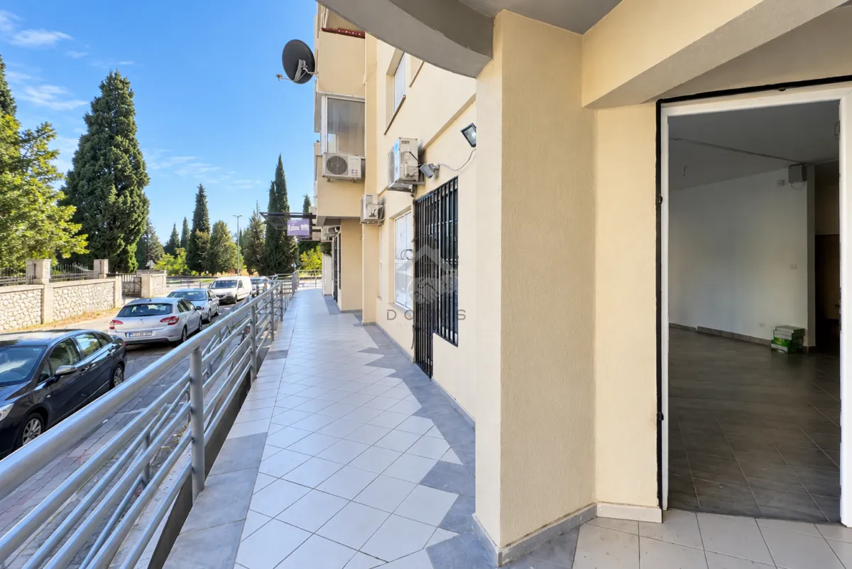 View of the tiled terrace and the entrance to the commercial space on the ground floor of the building.