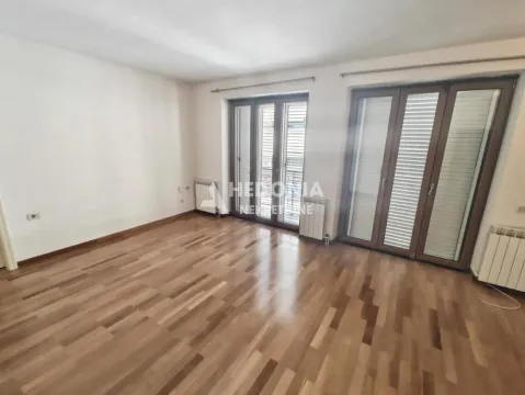 Empty room with wooden flooring and balcony doors. - image 10