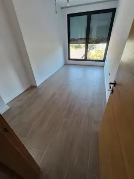 Empty room with light walls, wooden flooring, and a window. - image 17