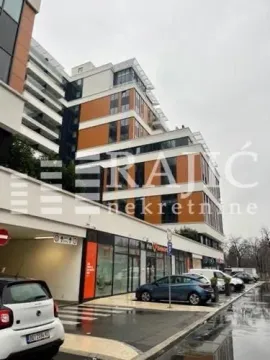 Exterior view of a modern residential and commercial building with parking and sidewalk. - image 7