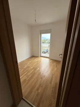 Prazna soba sa parketom i balkonskim vratima. - image 2