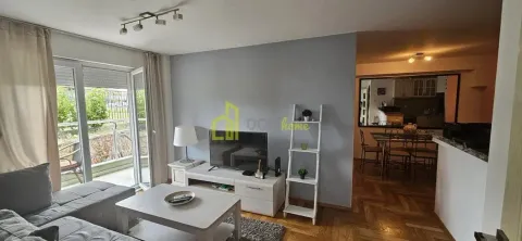 Dnevna soba sa garniturom, TV komodom i izlazom na terasu. - image 10
