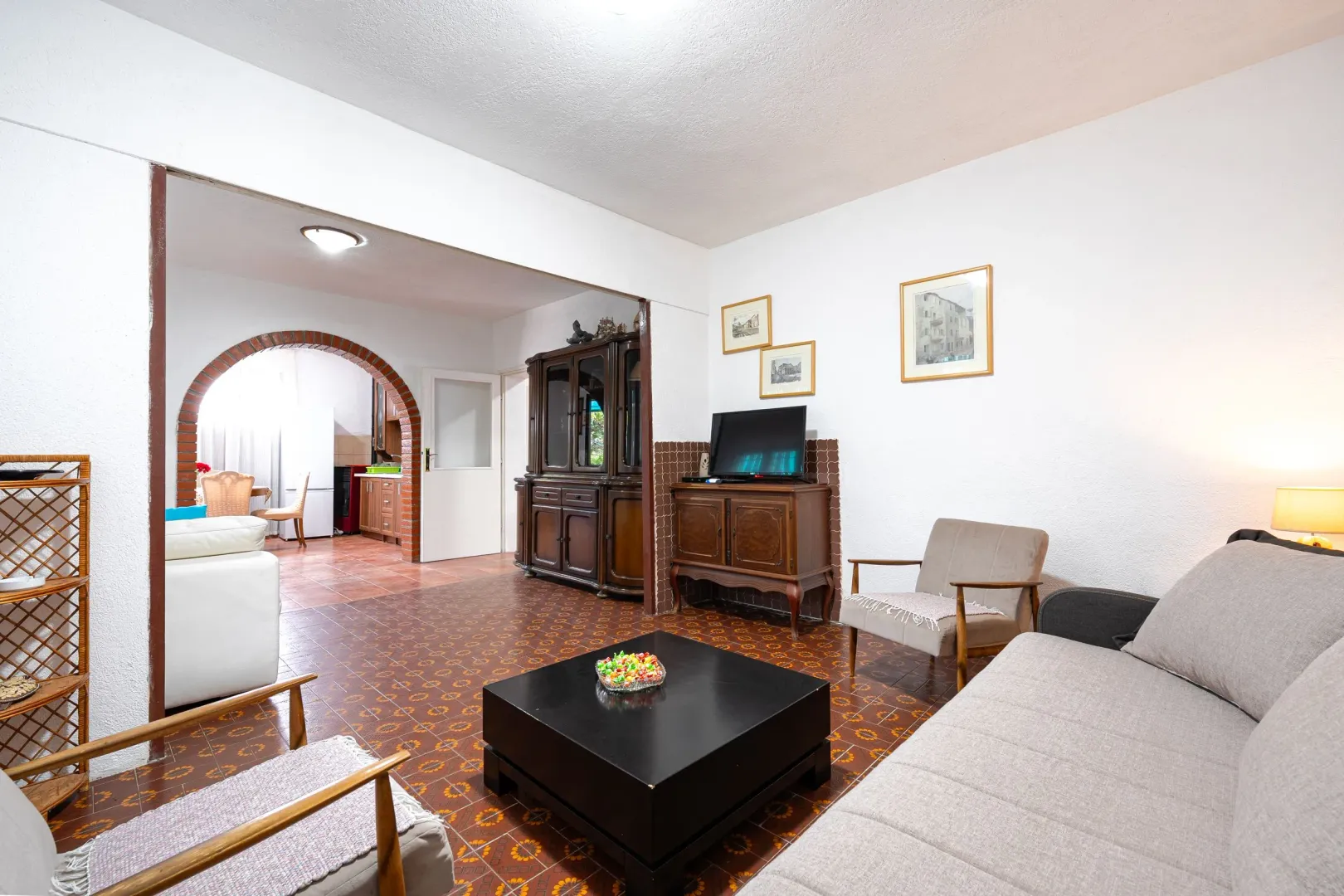 Living room with sofa, coffee table and view of the dining area through the archway.