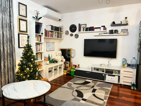 Living room with a television, bookshelf, and a Christmas tree. - image 8