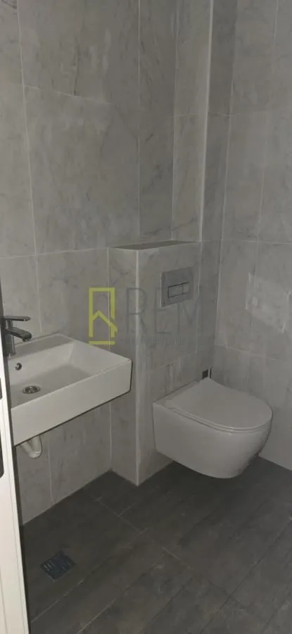 Moderne opremljeno kupatilo sa umivaonikom i ugradnom wc šoljom.