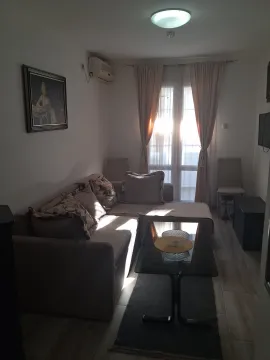 Living room with a sectional sofa, coffee table, and a window with curtains. - image 11