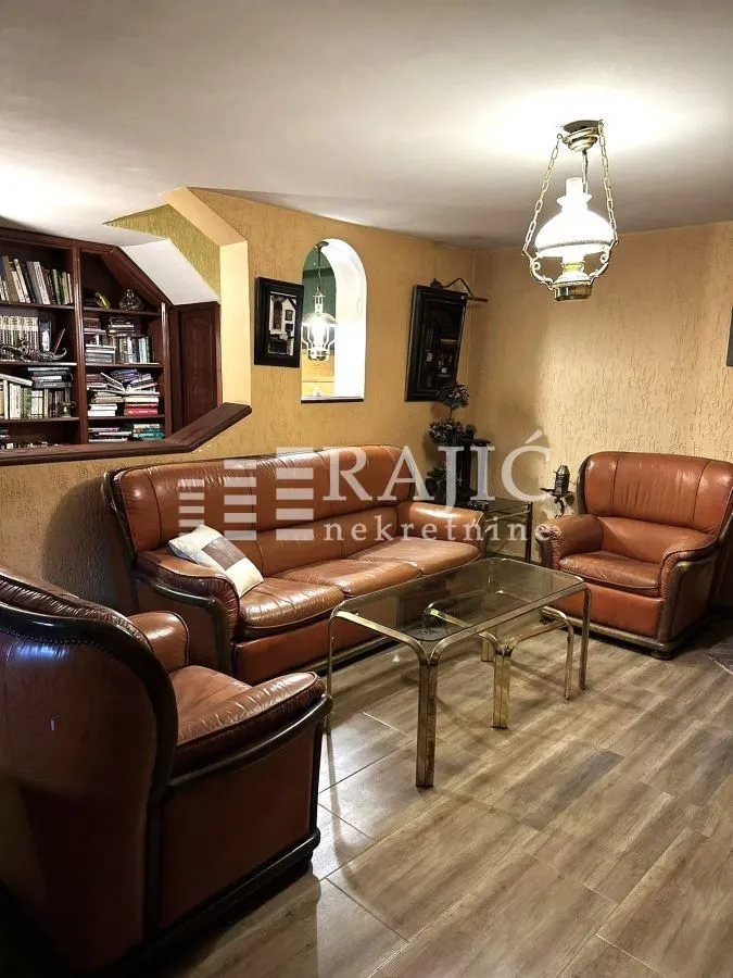 Living room with leather sofa set, coffee table and built-in bookshelf.