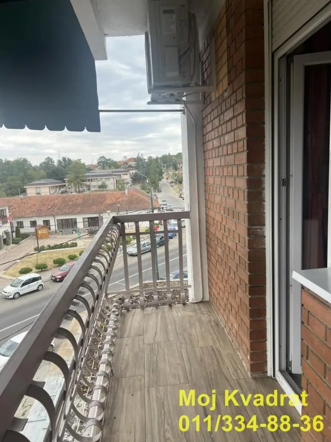 Balkon sa pogledom na ulicu i okolne zgrade.