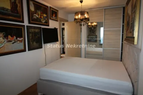Furnished bedroom with a double bed, wardrobe, and paintings on the wall. - image 9