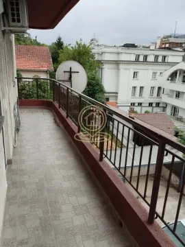 Pogled na prostrani balkon sa metalnom ogradom i okolnim zgradama. - image 40