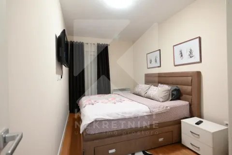 Namještena spavaća soba sa bračnim krevetom, noćnim stočićem i televizorom na zidu. - image 6