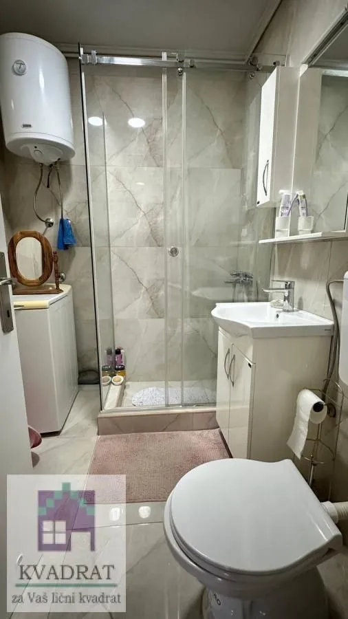 Kupatilo opremljeno tuš kabinom, umivaonikom i wc šoljom.