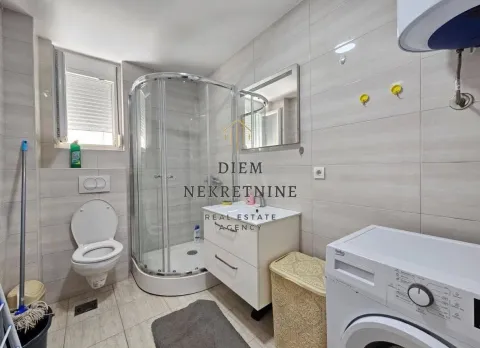 Compact bathroom with a shower cabin and a washing machine. - image 16