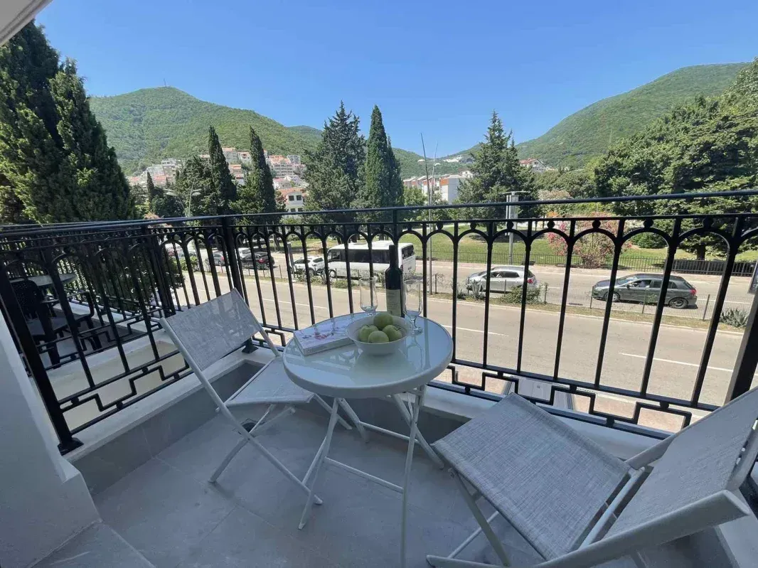 Furnished balcony with a table, chairs, and a view of the surroundings.