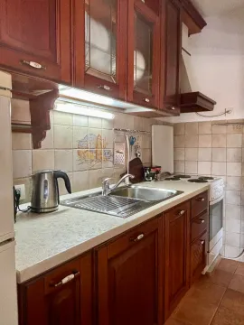 Kitchen with wooden cabinetry, a sink, and a built-in stove. - image 6