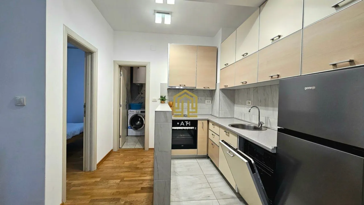 Small equipped kitchen with wooden elements and appliances.