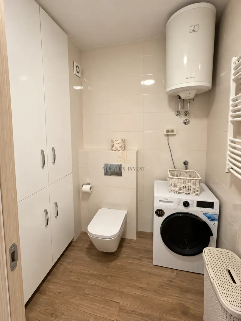 Bathroom equipped with sanitary fixtures, cabinets, water heater, and washing machine.