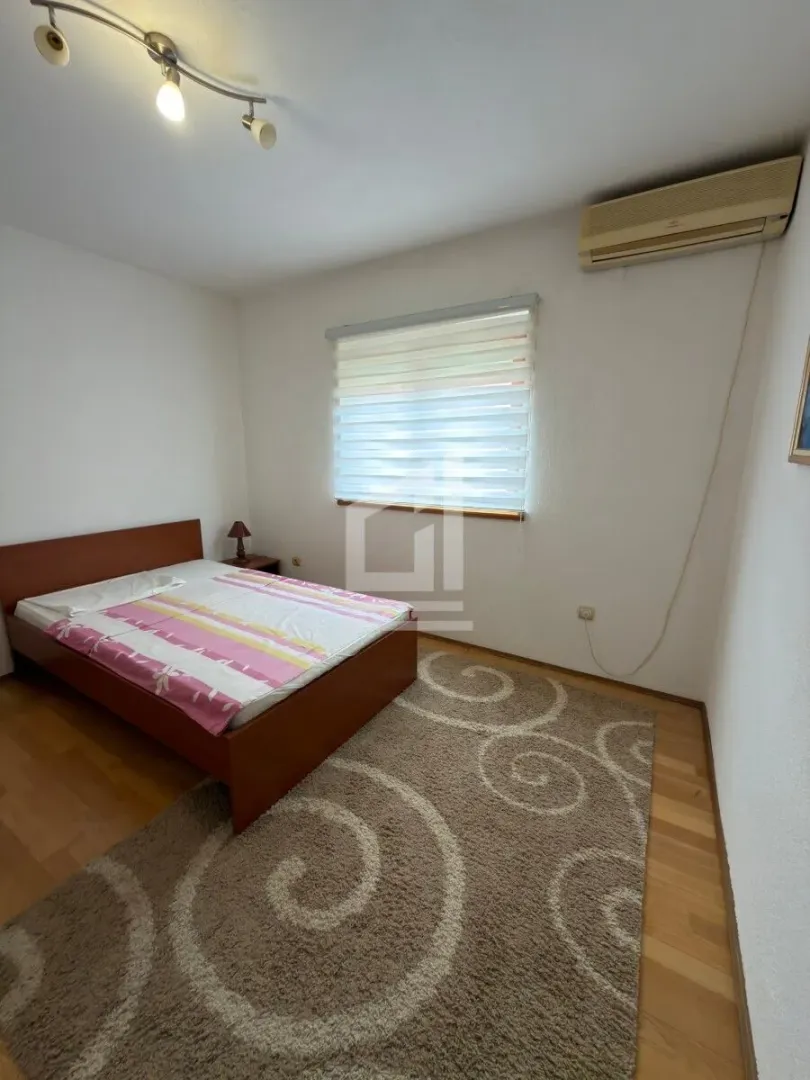 Bedroom with a double bed, window, and air conditioning.