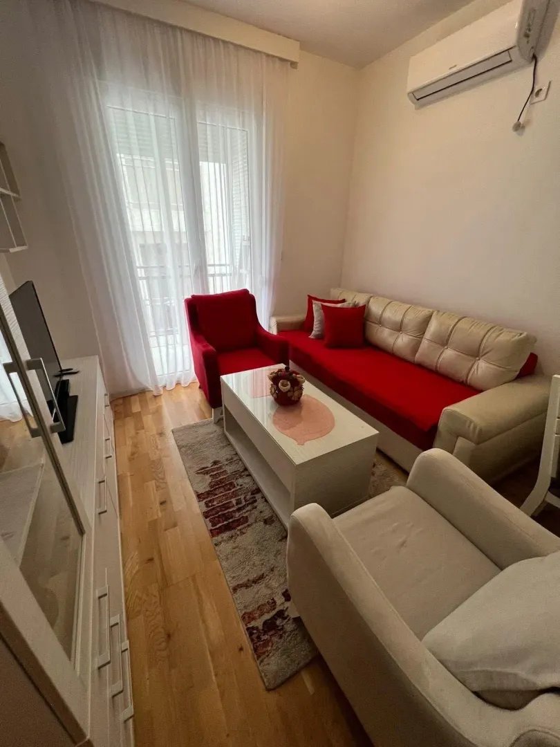 Living room with sofa, armchairs, coffee table and TV unit.