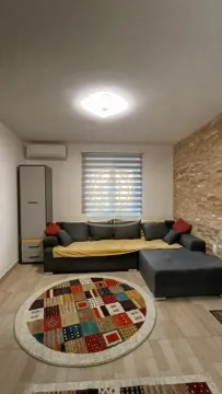 Dnevna soba sa ugaonom garniturom i dekorativnim kamenim zidom. - image 5