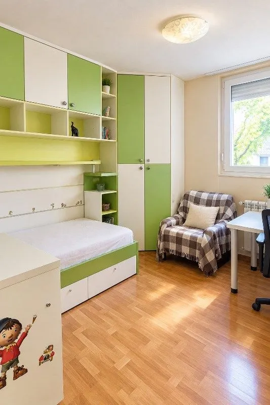 Children's bedroom with a bed, built-in wardrobes, an armchair, and a desk.