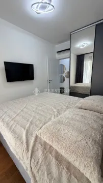 Modern bedroom with a double bed, wall-mounted TV, and mirrored wardrobe. - image 8