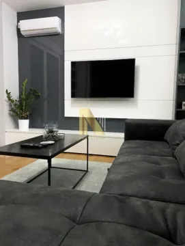 Dnevna soba sa ugaonom garniturom, stočićem i zidnim televizorom. - image 2