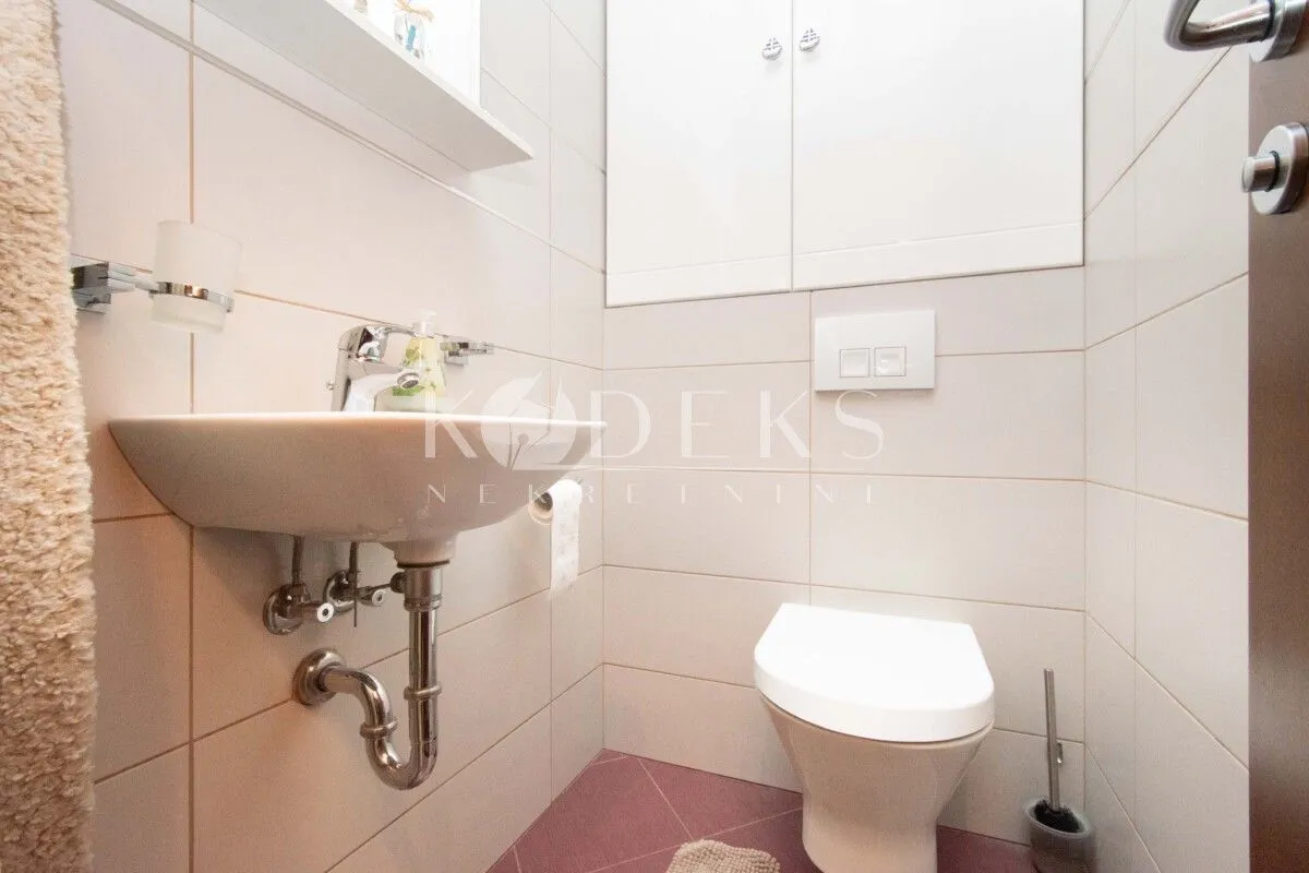 Small bathroom with a washbasin, toilet bowl, and wall-mounted cabinets.