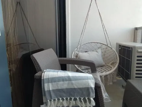 Furnished terrace with an armchair, rope swing, and decorative details. - image 10